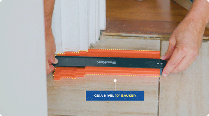 una persona usa una guía nivel de 10 pulgadas marca Bauker para tomar la forma irregular del piso de la cocina.