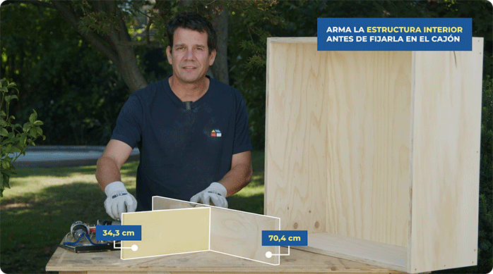 un hombre presenta las 2 divisiones interiores de la mesa de centro y forma una T con ellas.