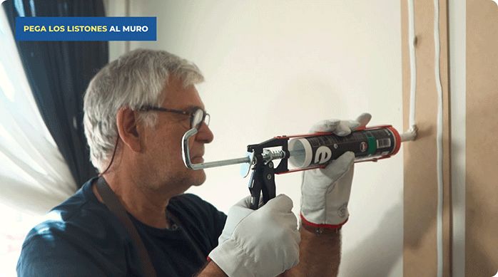 una persona aplica adhesivo high tack de rex usando una pistola calafatera en un listón de MDF.