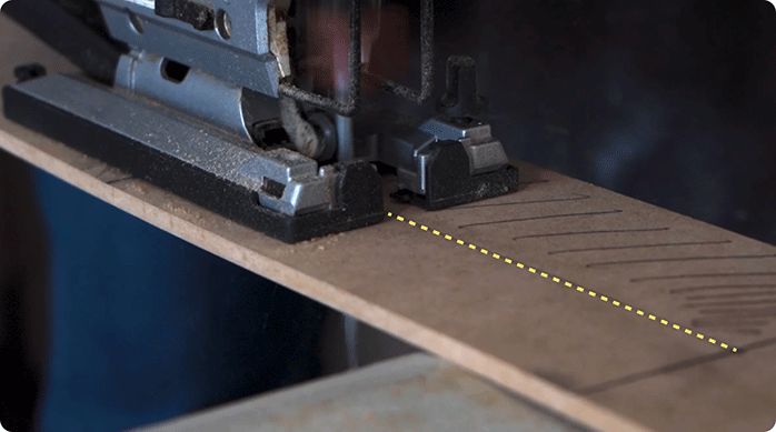 una persona corta un trozo de MDF usando una sierra caladora.