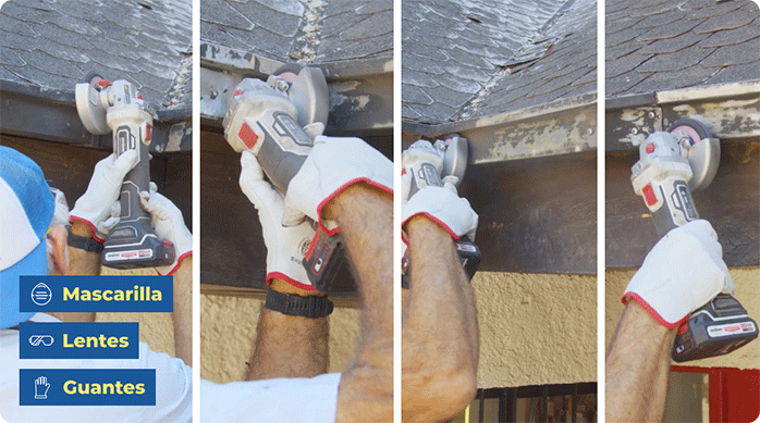 una persona con guantes de trabajo usa un esmeril angular con disco para retirar la pintura suelta de las canaletas de una casa.