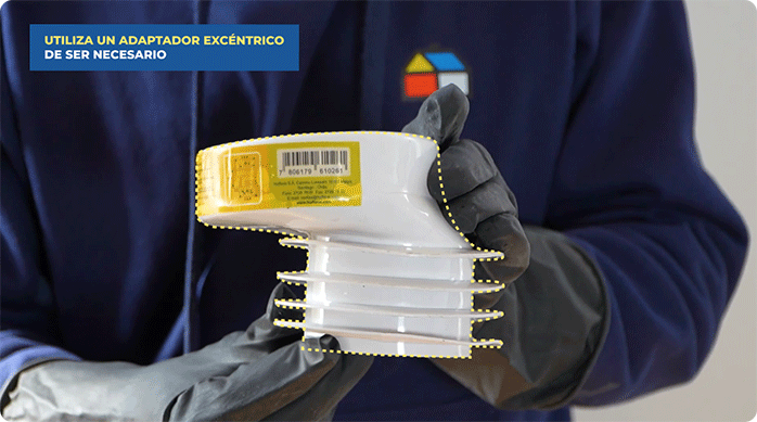 una persona sostiene un adaptador excéntrico para wc.