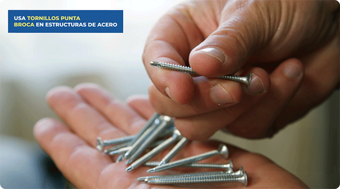 un hombre sostiene en sus manos tornillos punta broca.