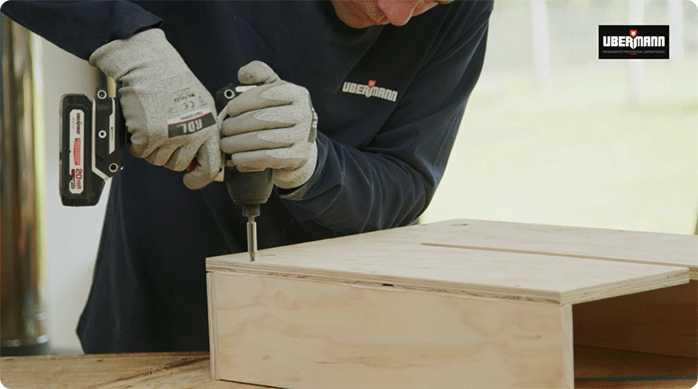 una persona fija un cajón del mueble isla de cocina.