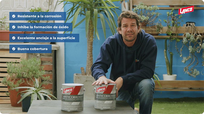 un hombre con polerón azul muestra la pintura anticorrosiva de la marca Lanco con la que va a proteger un techo de zinc.