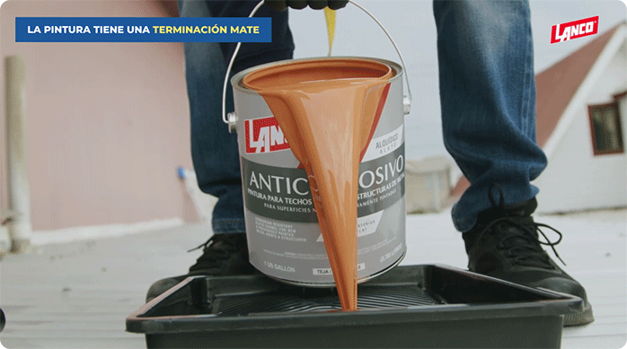 un hombre vierte pintura anticorrosiva en una bandeja para pintar.