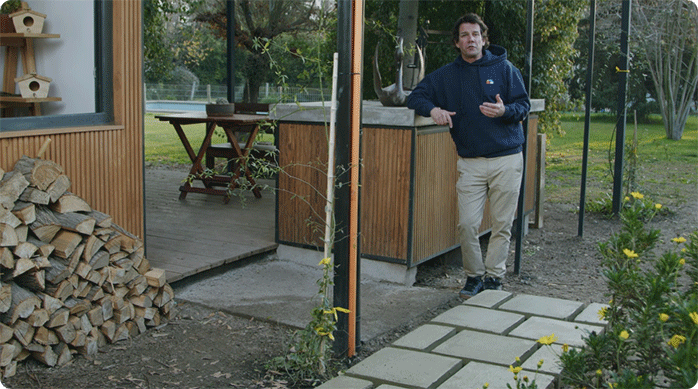 un hombre en un patio frente al sendero de hormigón que acaba de construir.