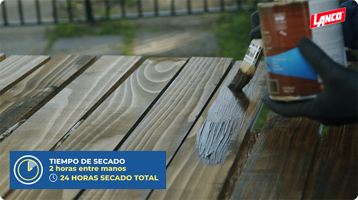 una persona aplica barniz Aquavar de Lanco en las tablas de madera usando una brocha.
