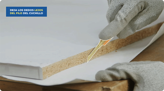 una persona corta con un cuchillo cartonero el excedente de papel mural de las puertas de clóset.