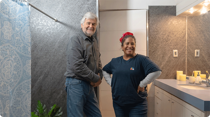 un hombre y una mujer muy felices en un baño luego de haber instalado SPC en los muros.