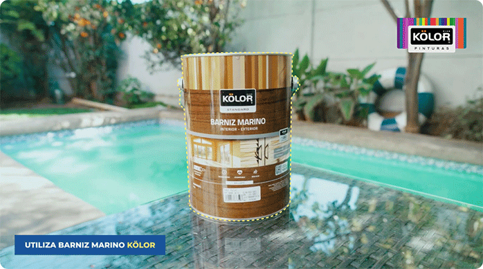 un tarro de barniz marino de la marca Kölor sobre una mesa, al lado de una piscina.