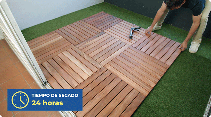 un hombre pega 9 palmetas de deck de madera en el piso de una terraza con adhesivo no más clavos.