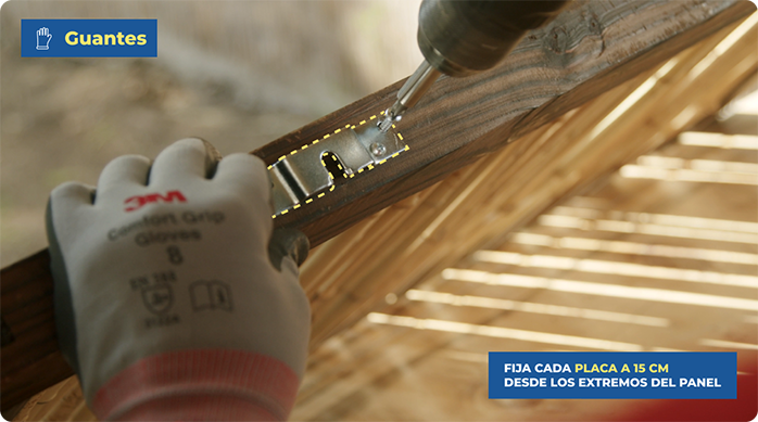 un hombre instala una placa en el panel de caña a 15 cm desde el extremo.