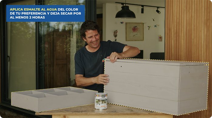 un hombre feliz luego de pintar su nuevo baúl organizador con esmalte al agua.