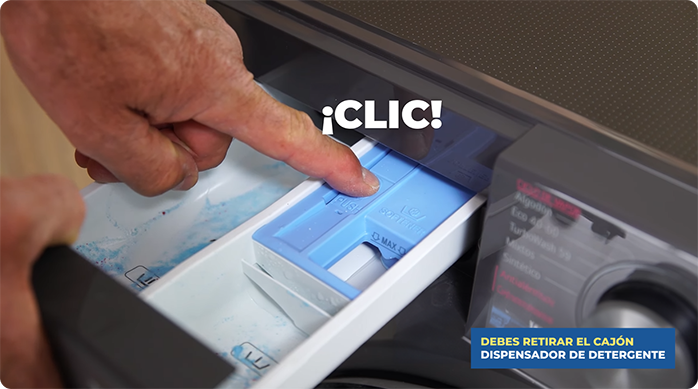 una persona desmonta el dispensador de detergente de una lavadora.