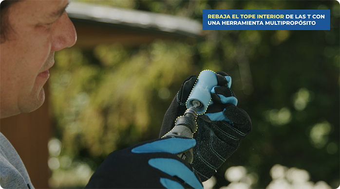 un hombre usa una herramienta multipropósito para rebajar las T de PVC.