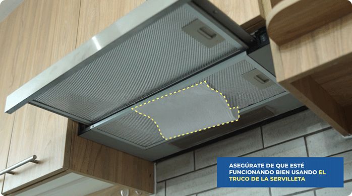una campana de cocina siendo sometida a la prueba de la servilleta.