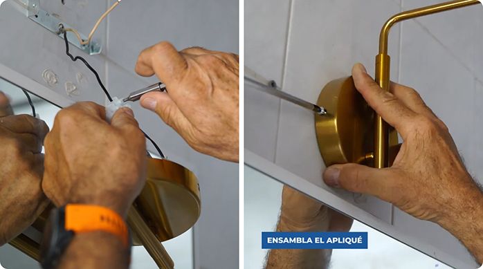 una persona conecta el apliqué nuevo en la red eléctrica del baño.