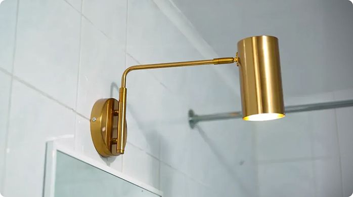 nuevo apliqué dorado recién instalado sobre el espejo del baño pequeño o baño de visitas.