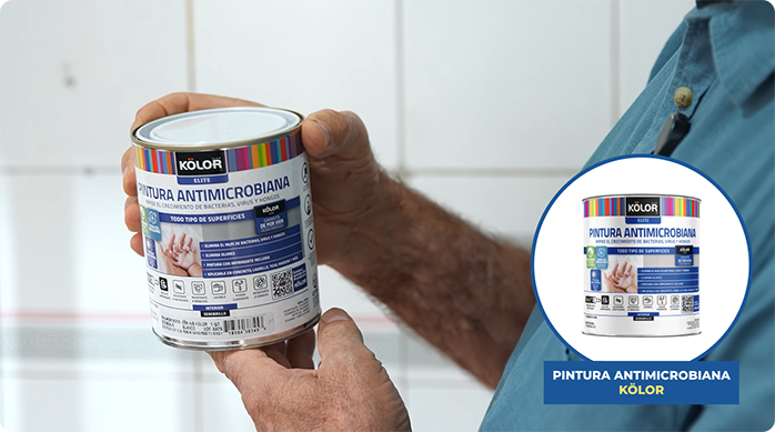 un hombre sostiene un tarro de pintura antimicrobiana Kölor.