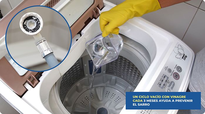 una persona vierte vinagre blanco en el tambor de una lavadora.