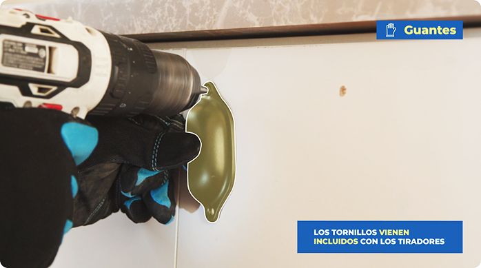 una persona instala un tirador de puerta con un desatornillador eléctrico y tornillos.