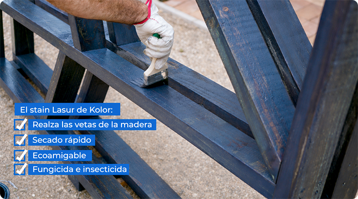 un hombre aplica stain lasur de Kölor protector para maderas en el leñero exterior.