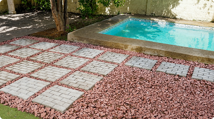 un patio con piso de adoquines modulares y gravilla.