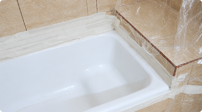 el contorno de una tina de baño completamente protegido con plástico protector y cinta para enmascarar.